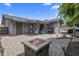 Spacious backyard featuring a cozy fire pit, covered patio, and well-maintained paver stone layout at 5061 E Edgewood Ave, Mesa, AZ 85206