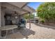 Serene outdoor space with a covered patio, grilling area, hot tub, and lush landscaping for relaxation at 5061 E Edgewood Ave, Mesa, AZ 85206