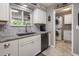 Well-lit kitchen with granite countertops, a black sink, and stainless steel appliances, and a view into the laundry room at 5061 E Edgewood Ave, Mesa, AZ 85206