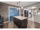 Kitchen island with granite countertop and dark wood cabinets with a view into the kitchen and stainless steel appliances at 5061 E Edgewood Ave, Mesa, AZ 85206