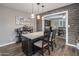 Kitchen island with granite countertop, dark wood cabinets, pendant lighting, and open layout to the dining room at 5061 E Edgewood Ave, Mesa, AZ 85206