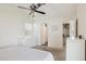 Bright bedroom featuring a ceiling fan, carpet floors, and a doorway to the ensuite bathroom at 510 S Kenwood Ln, Chandler, AZ 85226