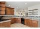 Kitchen with rich wood cabinetry, granite countertops, and black appliances, perfect for cooking at 510 S Kenwood Ln, Chandler, AZ 85226