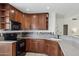 Kitchen with wooden cabinetry, tiled backsplash, and modern black appliances at 510 S Kenwood Ln, Chandler, AZ 85226