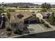 Aerial view of single-story home with tile roof, three-car garage, and backyard golf course view at 5450 N Globe Dr, Eloy, AZ 85131