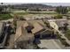 Aerial view of single-story home with tile roof, three-car garage, and backyard golf course view at 5450 N Globe Dr, Eloy, AZ 85131