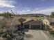 Aerial view of single-story home with tile roof, three-car garage, and backyard golf course view at 5450 N Globe Dr, Eloy, AZ 85131