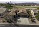 Aerial view of single-story home with tile roof, three-car garage, and backyard golf course view at 5450 N Globe Dr, Eloy, AZ 85131