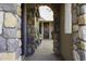 View of the front door through a stone entryway with brick flooring and decorative potted plants at 5450 N Globe Dr, Eloy, AZ 85131