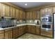 Kitchen featuring wood cabinets, granite counters, tile backsplash, a gas cooktop, and stainless steel appliances at 5450 N Globe Dr, Eloy, AZ 85131