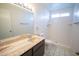 Bathroom showcasing a tiled shower, a sink with a granite countertop, and a mirror at 5608 W Greenbriar Dr, Glendale, AZ 85308