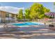 Community swimming pool with lounge chairs, tables, and umbrellas for residents' enjoyment at 6125 E Indian School Rd # 228, Scottsdale, AZ 85251