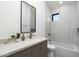 Stylish bathroom with gray cabinets, modern fixtures, and a shower-tub combo at 6338 N 10Th Dr, Phoenix, AZ 85013