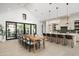 Open-concept dining area and kitchen with modern light fixture, hardwood floors, and stylish barstools at 6338 N 10Th Dr, Phoenix, AZ 85013