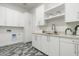 Well-organized laundry room with ample cabinet space, a sink, and patterned tile flooring at 6338 N 10Th Dr, Phoenix, AZ 85013