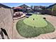 Entertaining backyard with a putting green, pool, patio seating, and desert landscaping at 6458 W Adobe Dr, Glendale, AZ 85308