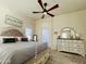 Well-lit bedroom with neutral walls, ceiling fan and a dresser with decor at 6458 W Adobe Dr, Glendale, AZ 85308