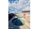 Backyard pool with a rock feature, umbrellas, and green putting green at 6458 W Adobe Dr, Glendale, AZ 85308