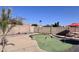 Backyard putting green with red flags, gravel border, and privacy wall at 6458 W Adobe Dr, Glendale, AZ 85308