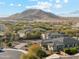 Stunning aerial view showcasing desert home with circular driveway, detached garage, and scenic mountain backdrop at 7662 W Artemisa Ave, Peoria, AZ 85383