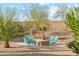 Inviting backyard fire pit with seating, surrounded by desert landscaping, offering a cozy gathering space for cooler evenings at 7662 W Artemisa Ave, Peoria, AZ 85383