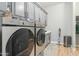 Modern laundry room features gray cabinetry, Samsung front load washer and dryer, and gray accent rug at 7662 W Artemisa Ave, Peoria, AZ 85383