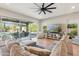 Bright living room featuring a large sectional couch, ceiling fan, and sliding glass doors to the patio at 7662 W Artemisa Ave, Peoria, AZ 85383