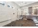 Gorgeous walk-in shower with marble walls, black fixtures and adjacent dual vanity area at 7662 W Artemisa Ave, Peoria, AZ 85383