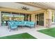 Covered outdoor living area with large sliding glass doors and comfortable seating at 7662 W Artemisa Ave, Peoria, AZ 85383