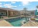 Inviting backyard pool with a Baja shelf, travertine coping and pergola-covered lounge area, perfect for relaxation and entertaining at 7662 W Artemisa Ave, Peoria, AZ 85383