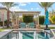 Relaxing poolside lounge area with comfortable seating under a pergola, complemented by manicured landscaping and lush greenery at 7662 W Artemisa Ave, Peoria, AZ 85383