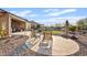 Outdoor patio with chairs overlooking the backyard featuring desert landscaping and seating areas at 7717 W Noble Prairie Way, Florence, AZ 85132