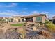 Backyard features desert landscaping, a putting green, and a covered patio perfect for relaxation at 7717 W Noble Prairie Way, Florence, AZ 85132