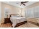 Bedroom with wood floors, neutral paint, shuttered windows, and a wood frame bed at 7717 W Noble Prairie Way, Florence, AZ 85132