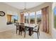 Dining room with a dark wood table and chairs, tile flooring, and large windows with natural light at 7717 W Noble Prairie Way, Florence, AZ 85132