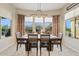 The dining room features a dark wood table and chairs, tile flooring, and large windows with backyard views at 7717 W Noble Prairie Way, Florence, AZ 85132