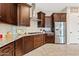 The kitchen features dark wood cabinets, stainless steel appliances, granite counters, and herringbone backsplash at 7717 W Noble Prairie Way, Florence, AZ 85132