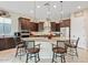 Modern kitchen featuring a granite-topped center island, stainless appliances, and stylish lighting at 7717 W Noble Prairie Way, Florence, AZ 85132