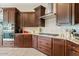 The kitchen features dark wood cabinets, stainless steel appliances, granite counters, and a herringbone backsplash at 7717 W Noble Prairie Way, Florence, AZ 85132