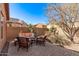 Outdoor patio set with peach colored cushions, a brick surround and desert landscape create a peaceful backyard living space at 7946 W Sonoma Way, Florence, AZ 85132