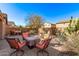 Desert landscaped backyard with paver patio, a stone wall, native plants, and multiple seating areas for entertaining at 7946 W Sonoma Way, Florence, AZ 85132