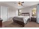 A simple bedroom featuring a ceiling fan, natural light, and clean carpeting at 7946 W Sonoma Way, Florence, AZ 85132