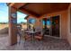 View of the covered patio with dining set, grill, and a thermometer outside of the sliding glass door into the home at 7946 W Sonoma Way, Florence, AZ 85132