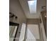 Bright bathroom with a skylight, dual sink vanity, and large mirror at 849 W Spur Ave, Gilbert, AZ 85233