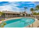 Inviting backyard featuring a sparkling swimming pool, lush palm trees, and a secure fence, perfect for outdoor relaxation at 8608 E Vernon Ave, Scottsdale, AZ 85257