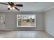 Bright living room featuring a large bay window and tile floors, complete with a ceiling fan and decorative front door at 8608 E Vernon Ave, Scottsdale, AZ 85257