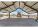 The interior view of a covered pavilion showing stone fireplace with an outdoor gathering area and open design at 919 W Peralta Pass, Apache Junction, AZ 85120