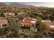 Expansive aerial shot of the property nestled in a community, showcasing lush landscaping and mountain backdrop at 9290 E Thompson Peak Pkwy # 142, Scottsdale, AZ 85255