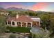 Stunning aerial view of the property featuring a well-manicured lawn, stone patio, and mountain views at 9290 E Thompson Peak Pkwy # 142, Scottsdale, AZ 85255