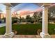 View of a beautiful backyard framed by arched columns, showcasing lush greenery and desert landscaping at 9290 E Thompson Peak Pkwy # 142, Scottsdale, AZ 85255